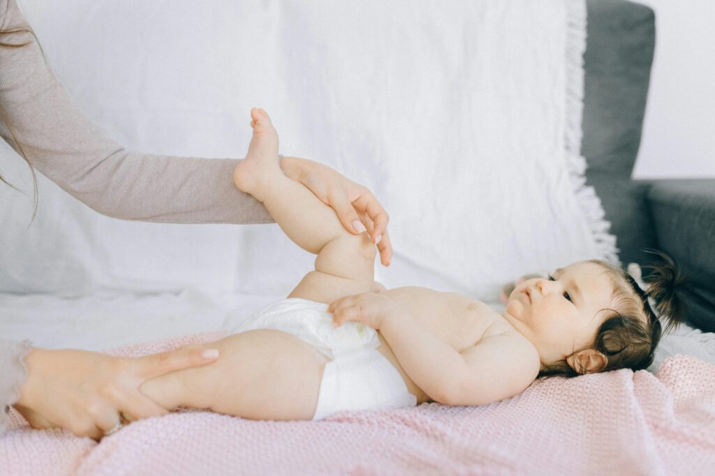 A tender moment with a baby receiving a gentle massage on a bed.
